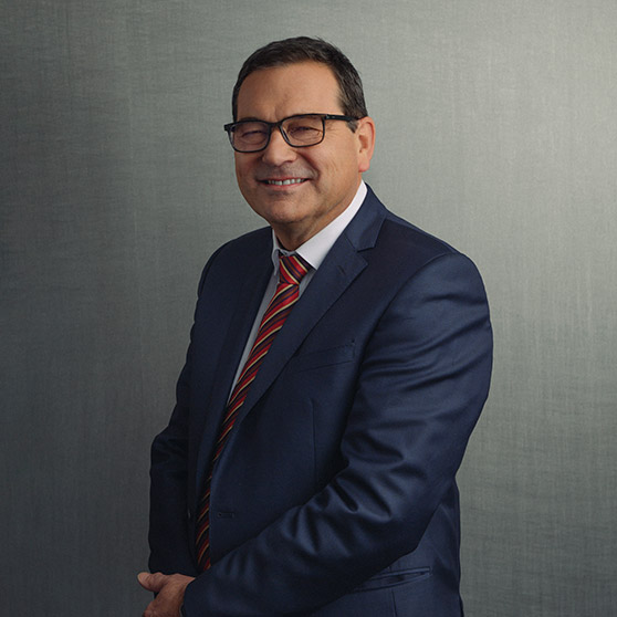 CEO Axel Beck from HOBART wearing a dark blue suit with a red striped tie against a gray background.
