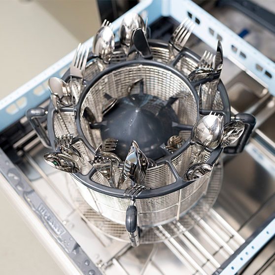 Overhead view of the rotating BESTECK PREMIUM basket inside a HOBART undercounter dishwasher, showing neatly arranged cutlery positioned for optimal cleaning results.