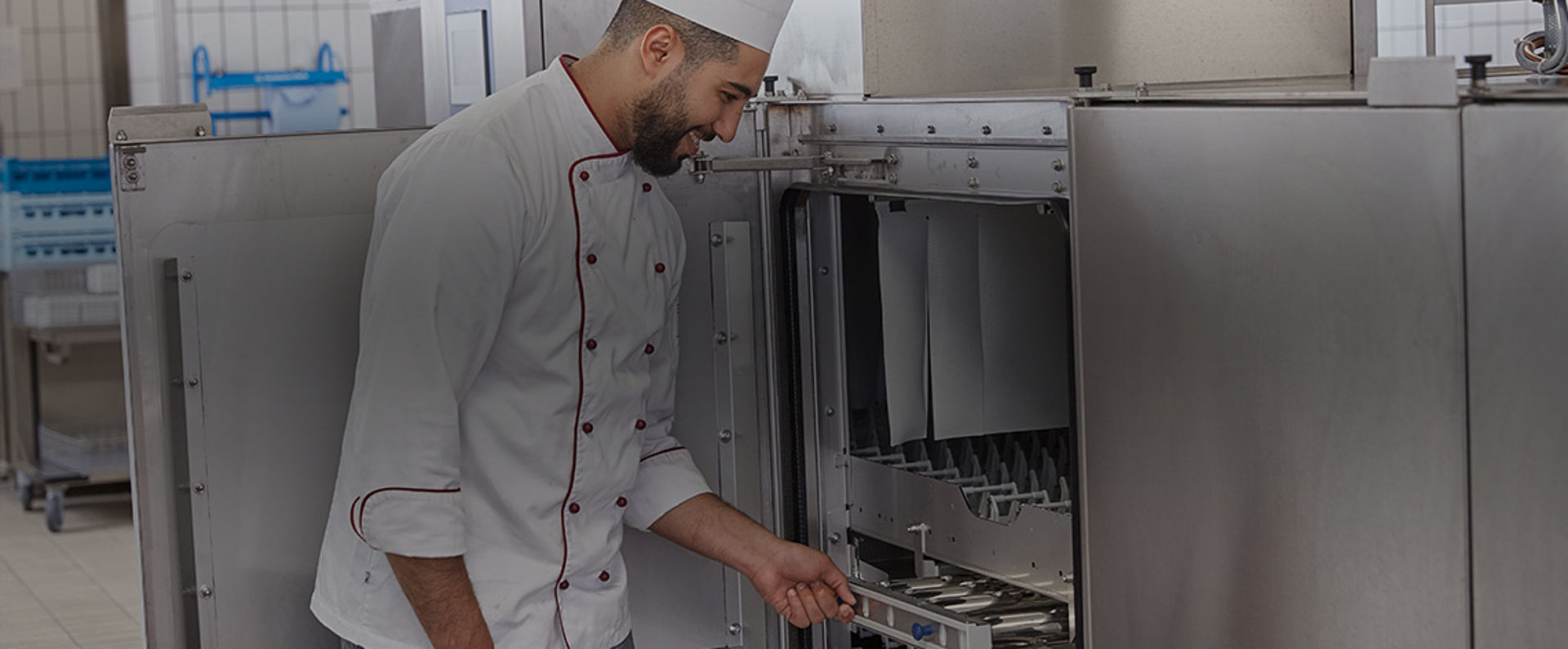 Staff member loading items into a HOBART industrial dishwasher as part of a streamlined, high‑efficiency cleaning routine in a professional food service environment.