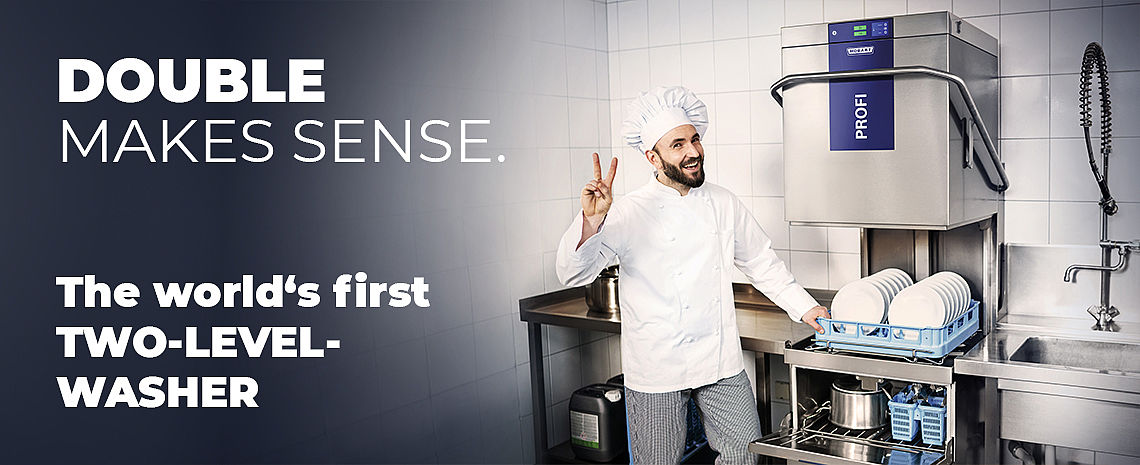 A person in kitchen attire standing next to a HOBART PROFI two‑level dishwashing machine inside a tiled commercial kitchen, with promotional text highlighting the concept of DOUBLE MAKES SENSE and the world’s first two‑level washer.