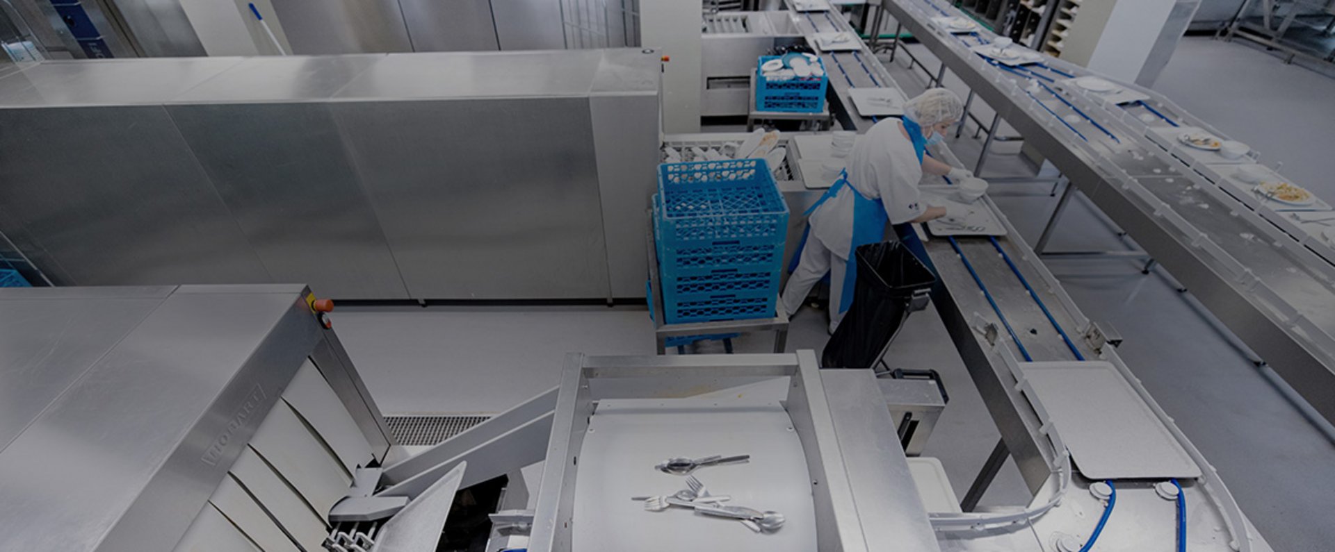 In the dishwashing area of the University Hospital Mannheim, the automated conveyor system and HOBART FTNi equipment handle large volumes of trays, cutlery, and kitchen items efficiently, showcasing a high‑capacity and hygiene‑focused setup for continuous meal‑service cleaning operations.