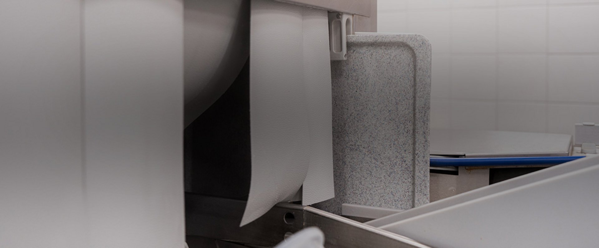Close‑up of the intake section of the HOBART autoLINE showing the guiding elements and entry flaps that direct trays and dishware into the conveyor washing system.
